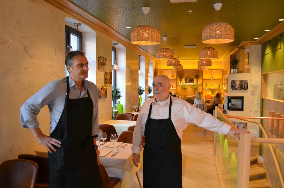 To verter i restaurantens spisesal, med dekkede bord og varme lamper