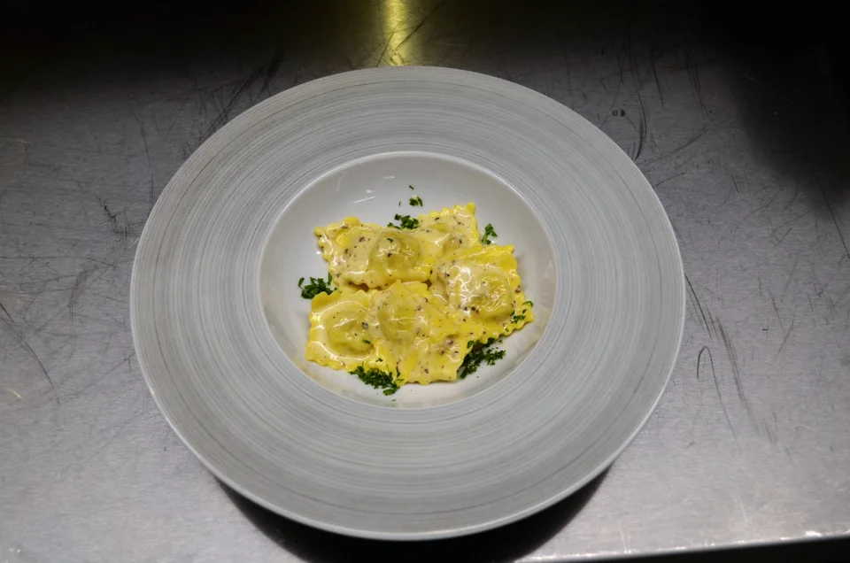 Ravioli i saus på en stor hvit tallerken